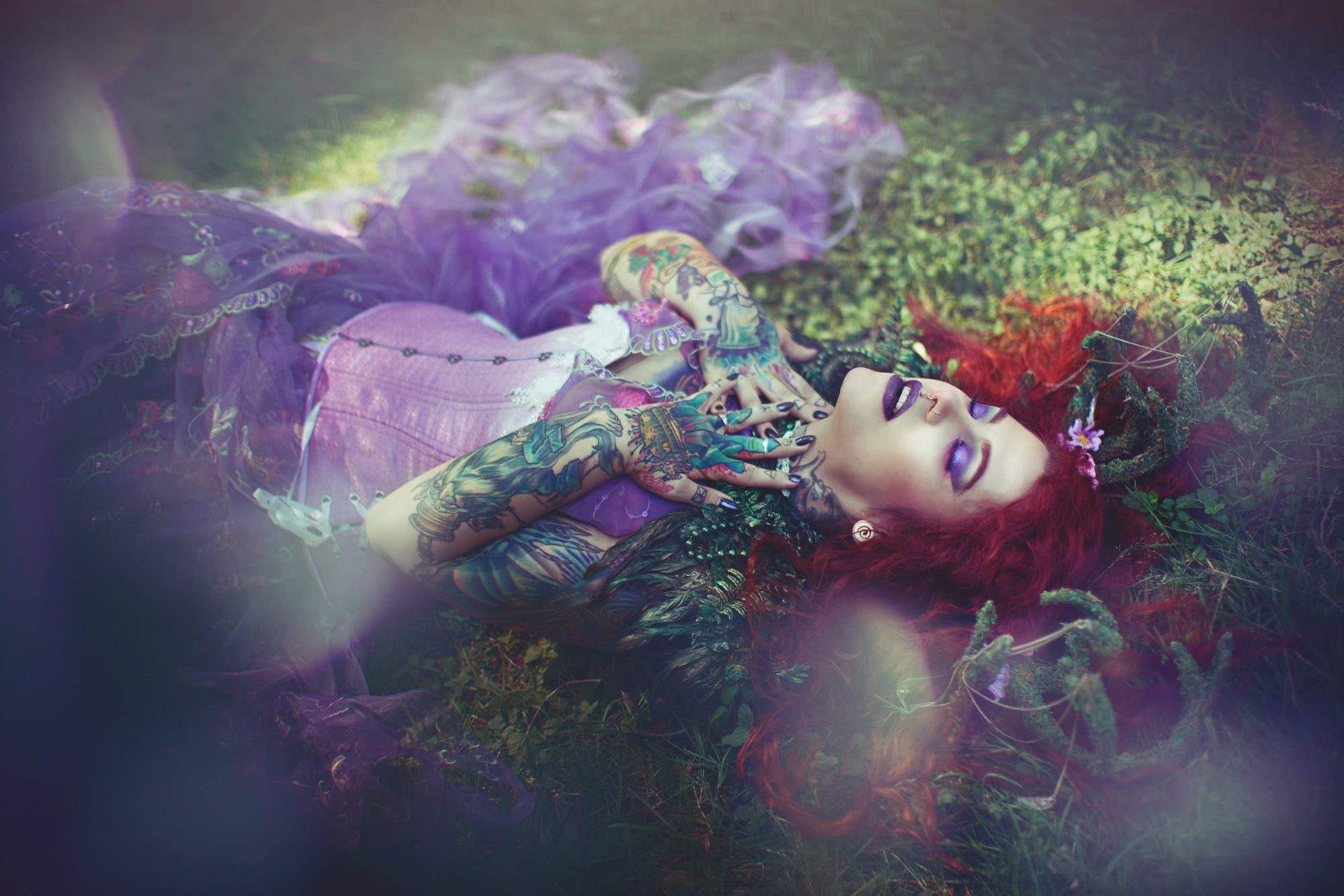 Lavender ombre brocade corset with white blossoms, hourglass silhouette, long length with adjustable side hip lacing, on a tattooed model with red hair wearing lavender gown lying in the grass