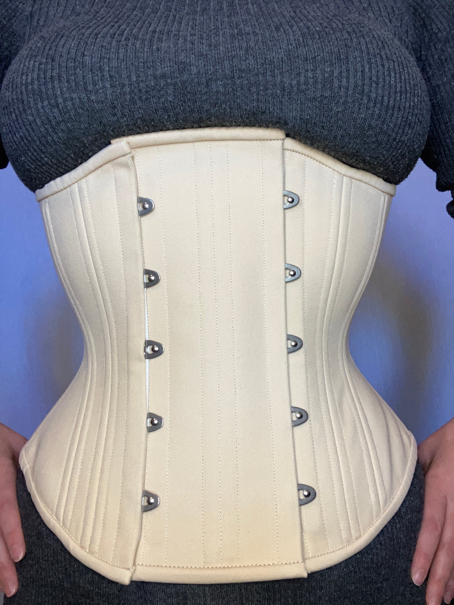 Person wearing a beige waist training corset with a 4-inch wide expander panel to make it fit better